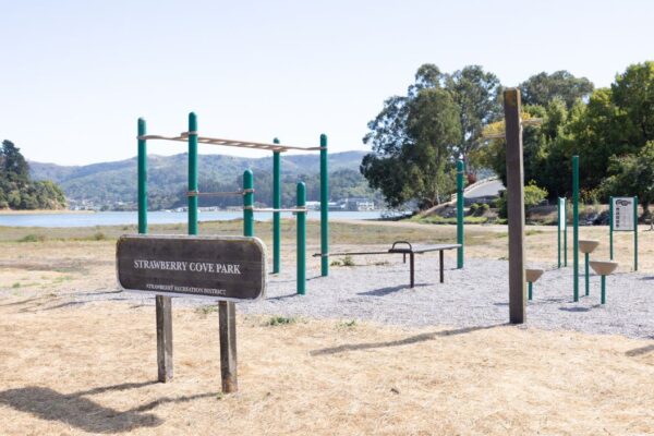 Outdoor fitness equipment and a sign reading 