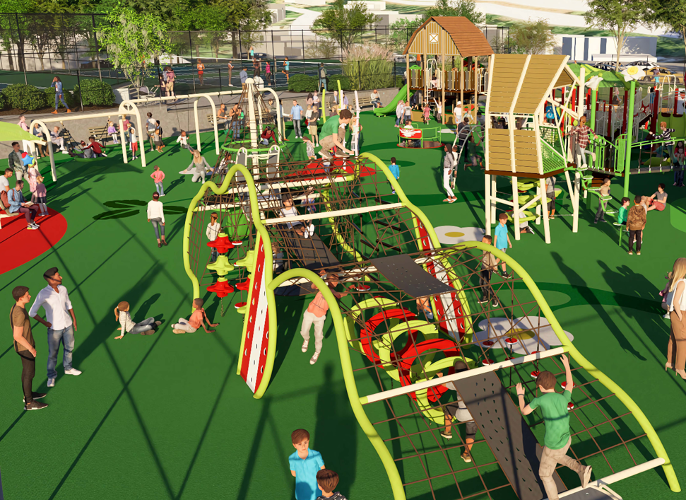 Children and adults are at a busy outdoor playground with climbing structures, slides, and green flooring on a sunny day.